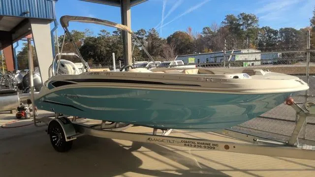 Slide: The Image of 2025 Hurricane SunDeck Sport 205 OB boat on trailer in marina setting. - 13
