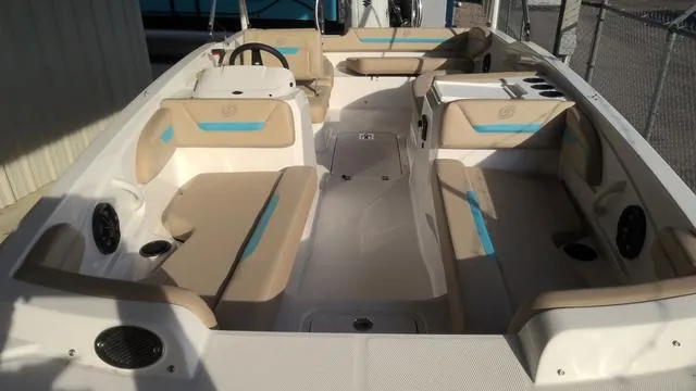 Slide: The Image of 2025 Hurricane SunDeck Sport 205 OB interior with beige and blue seating, spacious layout. - 14