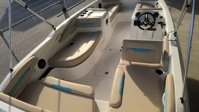 Slide: The Image of 2025 Hurricane SunDeck Sport 205 OB interior with beige seating and steering console. - 16