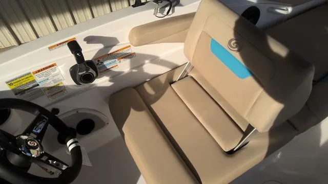Slide: The Image of 2025 Hurricane SunDeck Sport 205 OB boat interior with beige seating and steering wheel. - 23