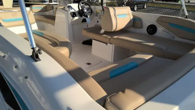 Slide: The Image of 2025 Hurricane SunDeck Sport 205 OB interior with beige and blue seating, steering console, and spacious layout. - 7