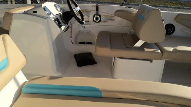 Slide: The Image of 2025 Hurricane SunDeck Sport 205 OB boat interior with beige seating and steering console. - 9