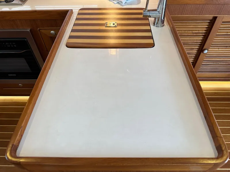 Slide: The Image of Helmsman Trawlers 43E PILOTHOUSE 2023 kitchen sink with wooden countertop and faucet. - 19