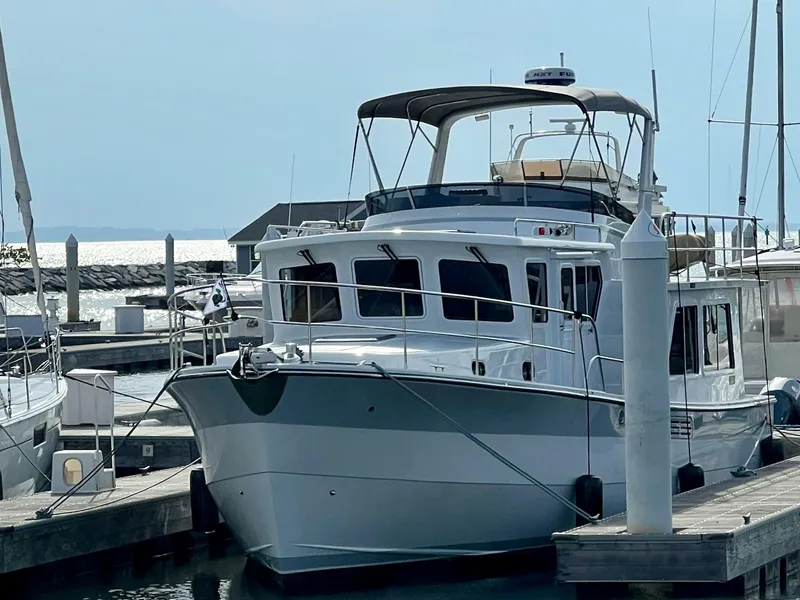 Slide: The Image of 2023 Helmsman Trawlers 43E Pilothouse docked at marina, front view. - 2
