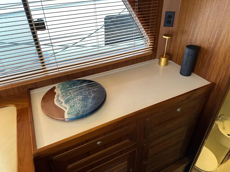 Slide: The Image of Interior of 2023 Helmsman Trawlers 43E Pilothouse with wooden cabinetry and decorative accents. - 23