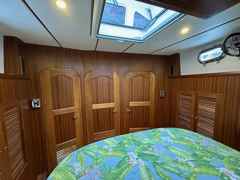 Slide: The Image of Helmsman Trawlers 43E PILOTHOUSE 2023 cabin with wood paneling and skylight. - 26