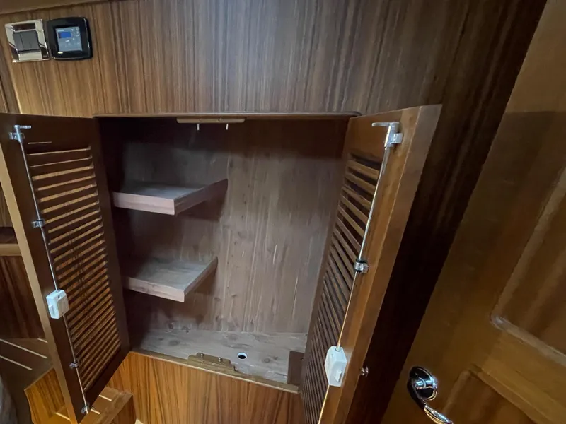 Slide: The Image of Open wooden cabinet with shelves inside Helmsman Trawlers 43E Pilothouse, 2023 model. - 28