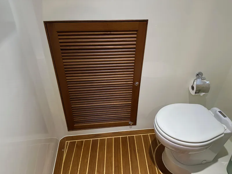 Slide: The Image of 2023 Helmsman Trawlers 43E Pilothouse bathroom with wooden flooring and modern toilet design. - 32