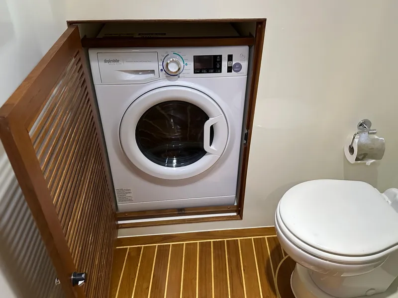 Slide: The Image of Laundry area with washer and toilet in 2023 Helmsman Trawlers 43E Pilothouse. - 33