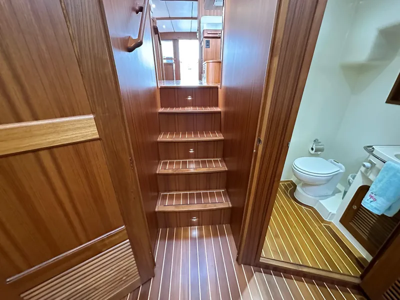 Slide: The Image of Interior of 2023 Helmsman Trawlers 43E Pilothouse with wooden stairs and bathroom. - 34