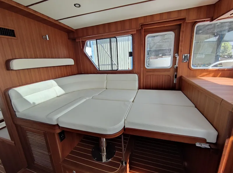 Slide: The Image of Luxurious interior of 2023 Helmsman Trawlers 43E Pilothouse with plush seating and wood finish. - 37