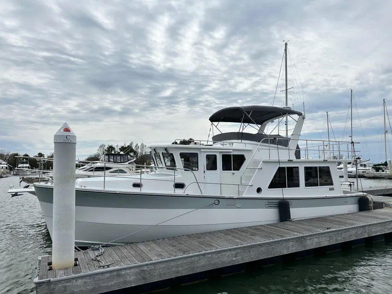 Slide: The Image of 2023 Helmsman Trawlers 43E Pilothouse docked at a marina under cloudy skies. - 4