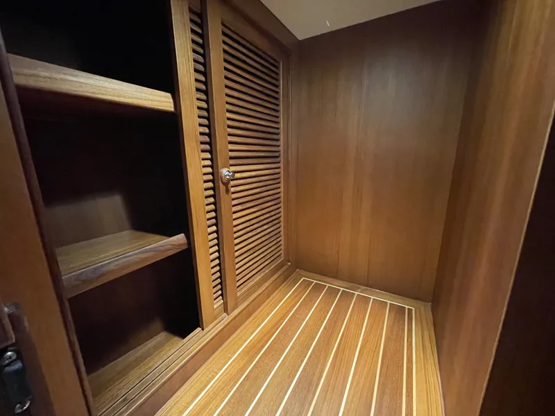 Slide: The Image of Interior of 2023 Helmsman Trawlers 43E PILOTHOUSE with wooden shelves and louvered door. - 41