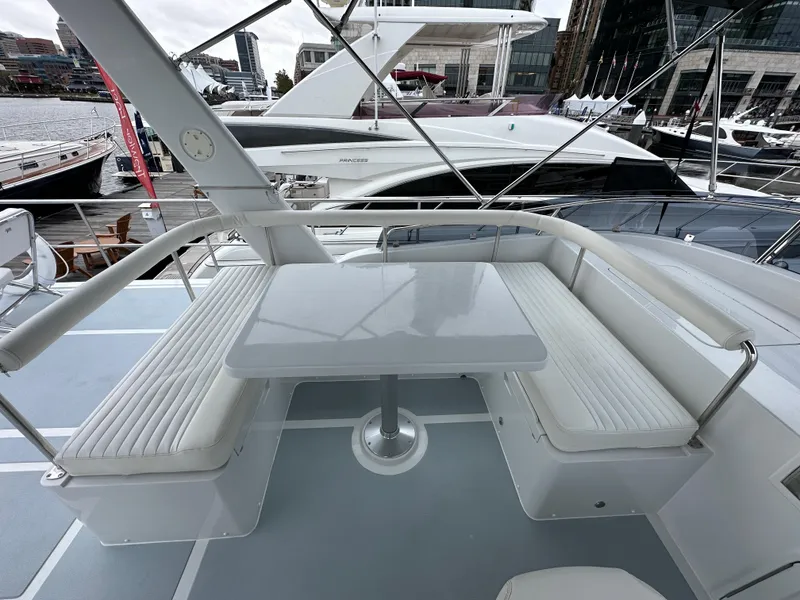 Slide: The Image of Helmsman Trawlers 43E PILOTHOUSE 2023, outdoor seating area with table on a yacht. - 43