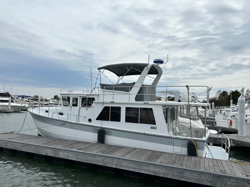 Slide: The Image of 2023 Helmsman Trawlers 43E Pilothouse docked at a marina under cloudy skies. - 5