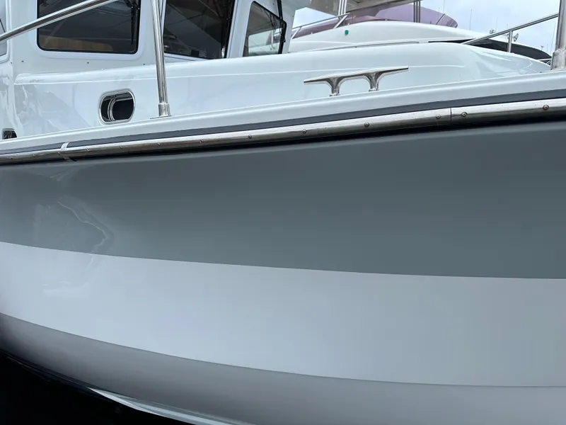Slide: The Image of 2023 Helmsman Trawlers 43E Pilothouse, sleek white and gray hull detail. - 6