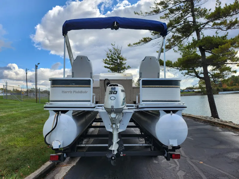 Slide: The Image of 2002 Harris FloteBote 220 Fisherman pontoon boat on trailer by a lake. - 2