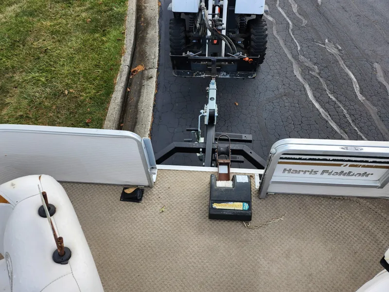 Slide: The Image of 2002 Harris FloteBote 220 Fisherman boat hitched to a vehicle on a paved road. - 24