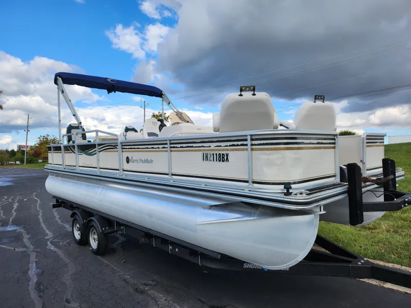 Slide: The Image of 2002 Harris FloteBote 220 Fisherman pontoon boat on trailer under cloudy sky. - 5