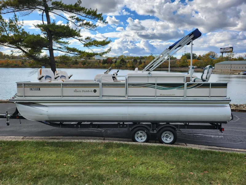 Slide: The Image of 2002 Harris FloteBote 220 Fisherman pontoon boat on trailer by a lake. - 9