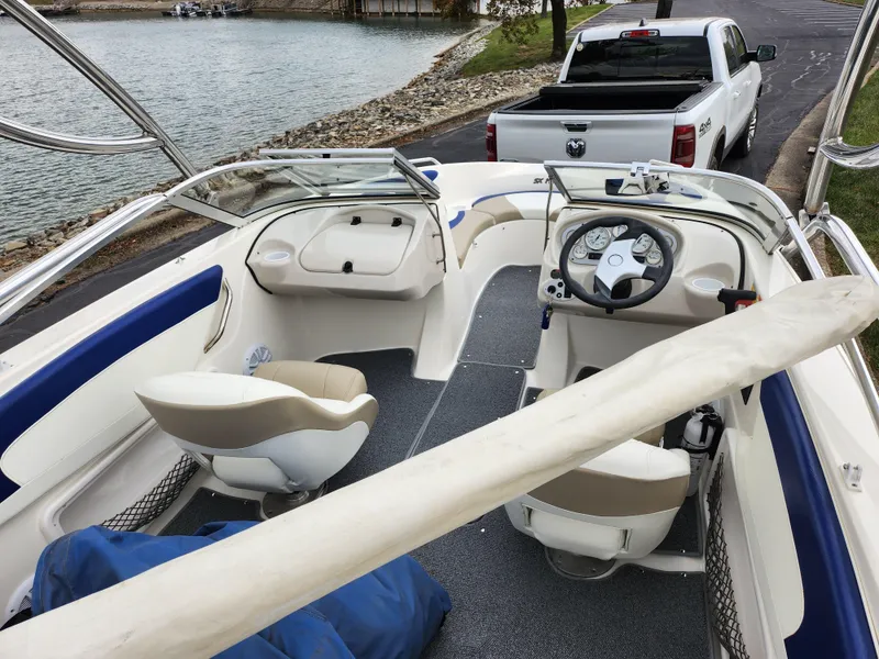 Slide: The Image of 2006 Glastron SX 195 boat interior near a lake with a parked truck. - 10