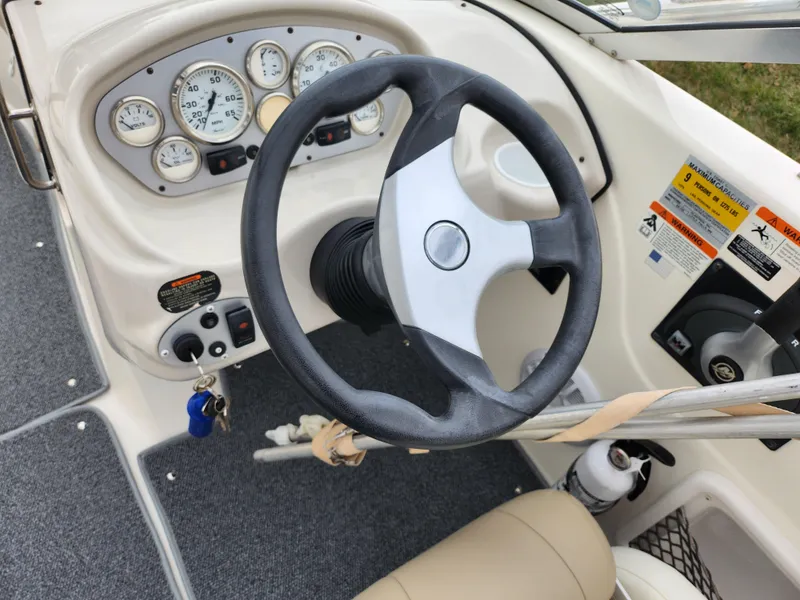Slide: The Image of 2006 Glastron SX 195 boat dashboard with steering wheel and gauges. - 14