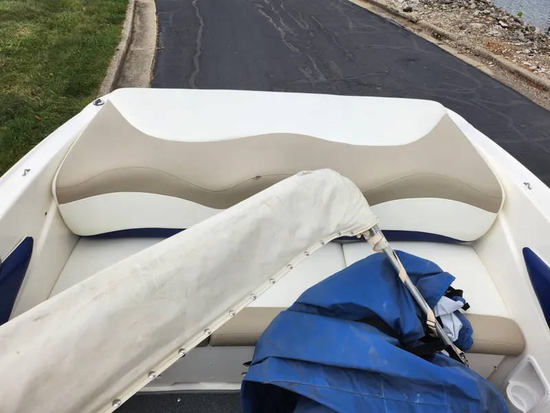 Slide: The Image of 2006 Glastron SX 195 boat interior with beige and white seating, blue cover on deck. - 22