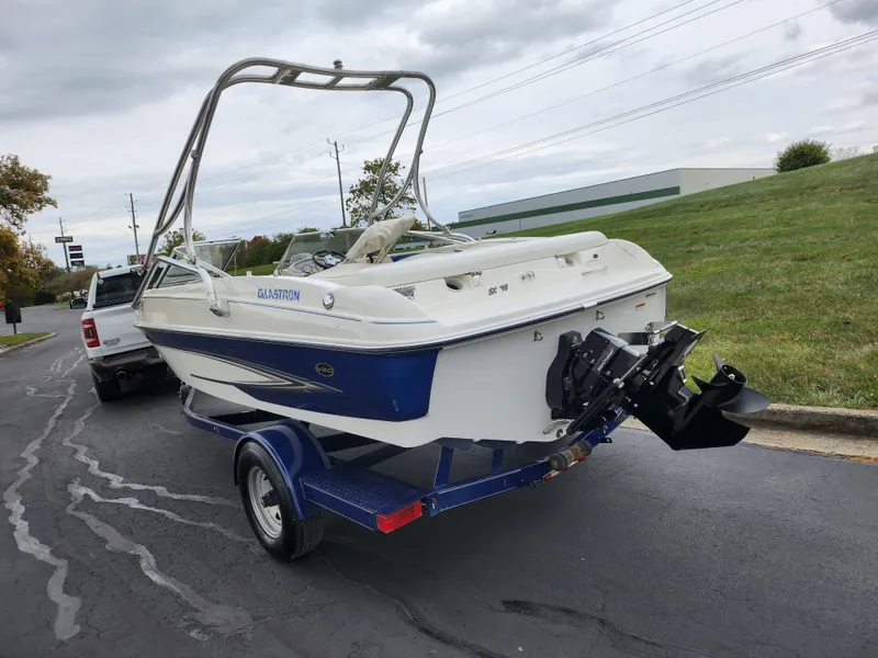 Slide: The Image of 2006 Glastron SX 195 boat on trailer, parked on a paved road. - 3