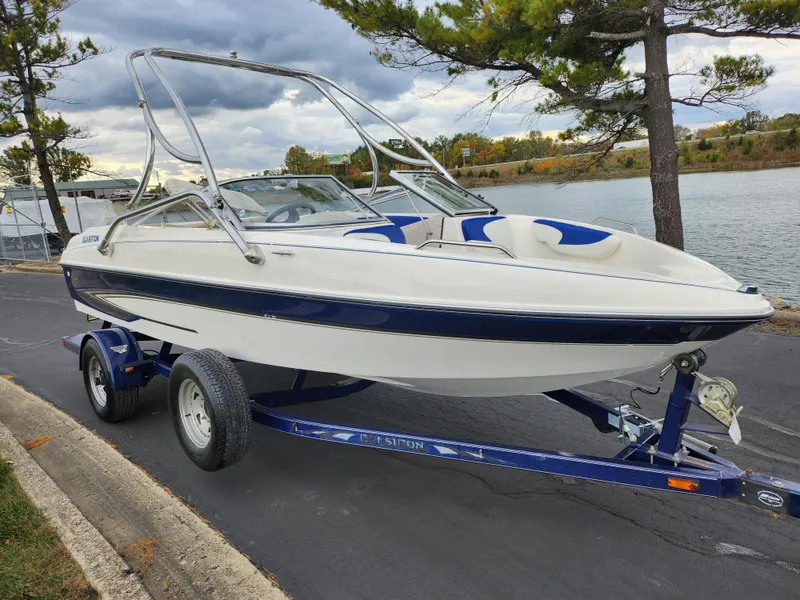 Slide: The Image of 2006 Glastron SX 195 boat on trailer by a lakeside road. - 8