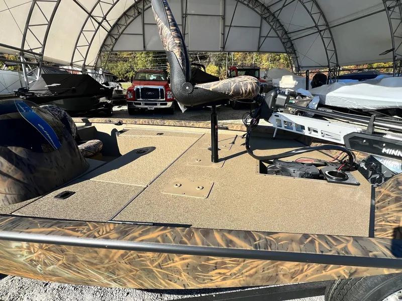 Slide: The Image of 2025 G3 Sportsman 1610 Vinyl boat under canopy, featuring camo design and fishing equipment. - 11