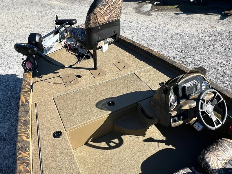 Slide: The Image of 2025 G3 Sportsman 1610 Vinyl boat interior with camo seats and steering console. - 16