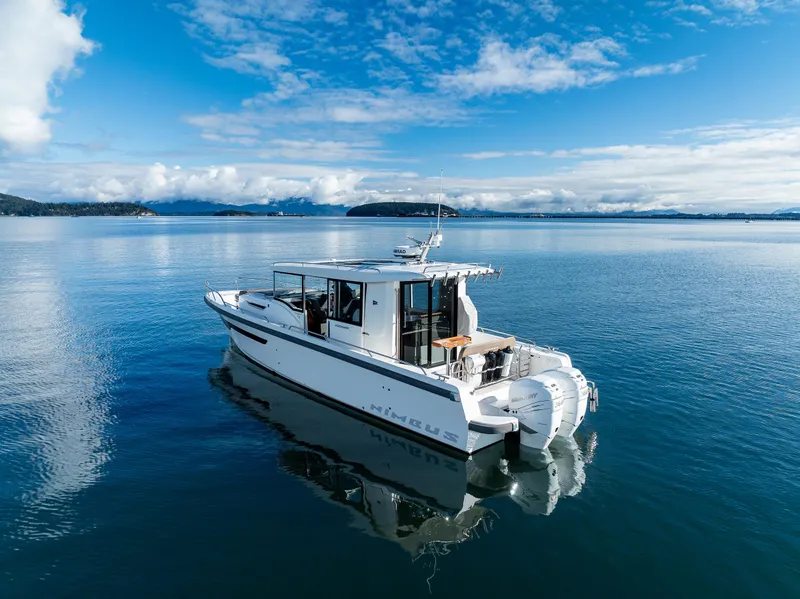 Slide: The Image of Nimbus C11 2021 boat cruising on a calm, scenic lake under a clear blue sky. - 19