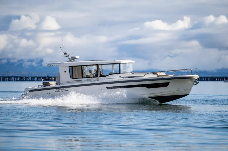 Slide: The Image of 2021 Nimbus C11 boat cruising on calm water under cloudy skies. - 2