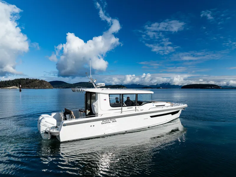 Slide: The Image of Nimbus C11 2021 boat cruising on a serene lake under a clear blue sky. - 30