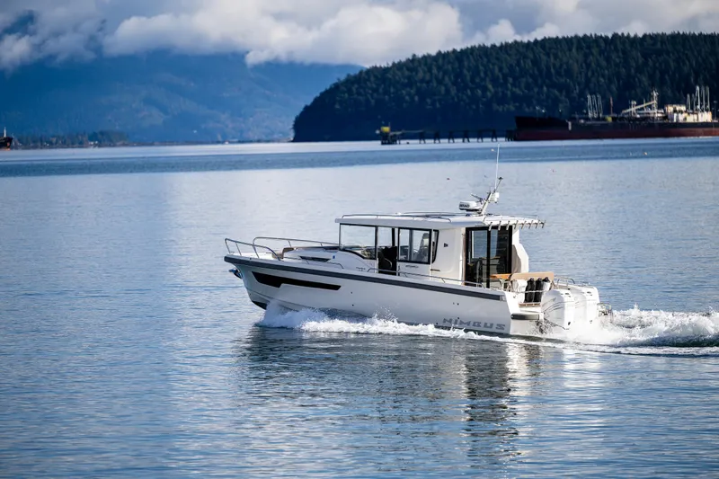 Slide: The Image of Nimbus C11 2021 boat cruising on a serene lake with forested hills in the background. - 37