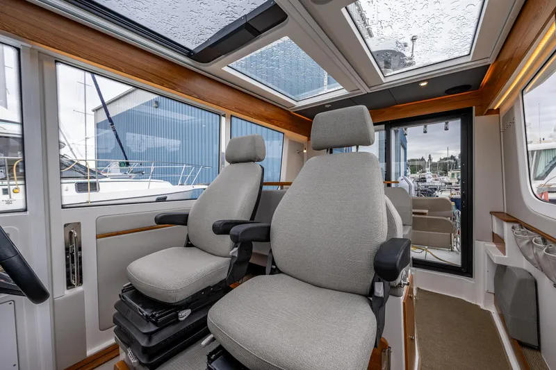 Slide: The Image of Interior of 2021 Nimbus C11 boat with two cushioned seats and panoramic windows. - 4