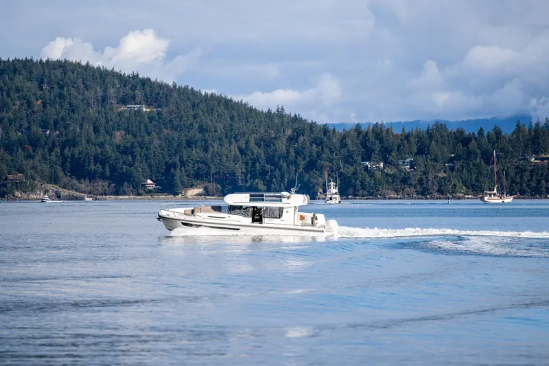 Slide: The Image of Nimbus C11 boat cruising on a serene lake with forested hills in the background. - 40