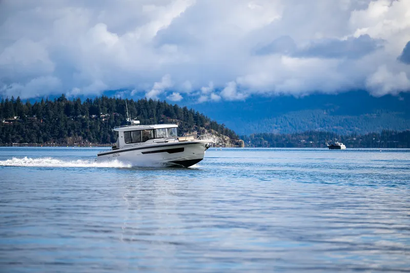 Slide: The Image of Nimbus C11 boat cruising on a serene lake with forested hills in the background. - 41