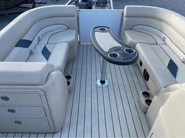 Slide: The Image of 2023 SunCatcher Select 22SS boat interior with beige seating and central table. - 9