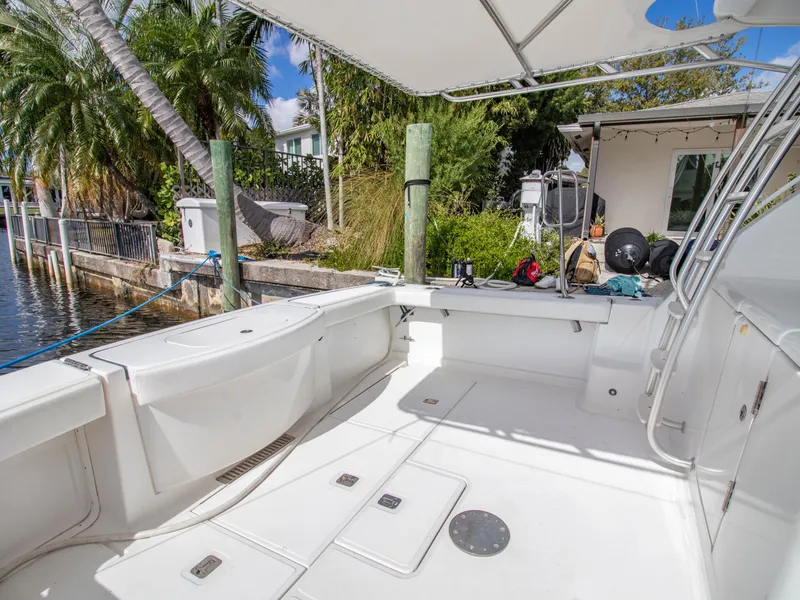 Slide: The Image of 2008 Tiara Yachts 3900 Convertible boat docked, featuring spacious deck and tropical surroundings. - 49