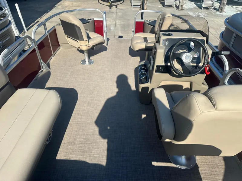 Slide: The Image of 2025 Sun Tracker Bass Buggy 18 DLX pontoon boat interior with beige seating and steering console. - 2