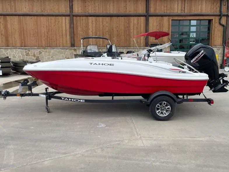 The Image of 2025 Tahoe T16 boat, red and white, on trailer, parked outdoors. - 0