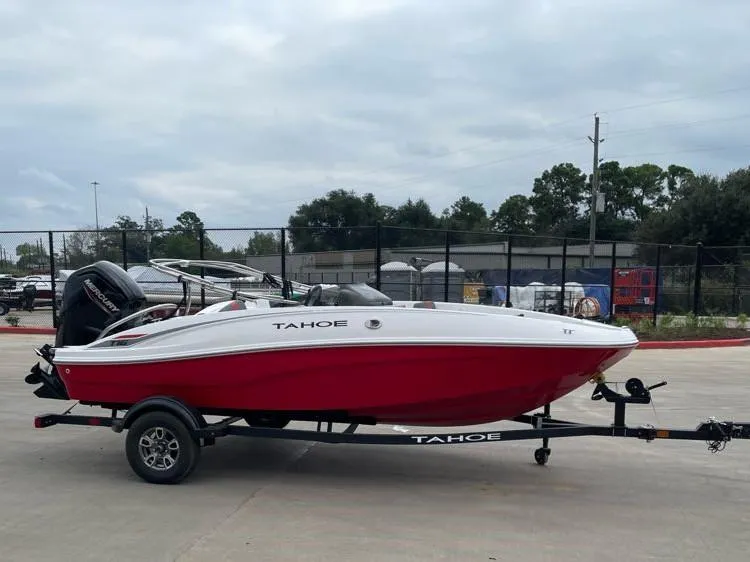 Slide: The Image of 2025 Tahoe T16 boat with red hull on trailer in parking lot. - 1