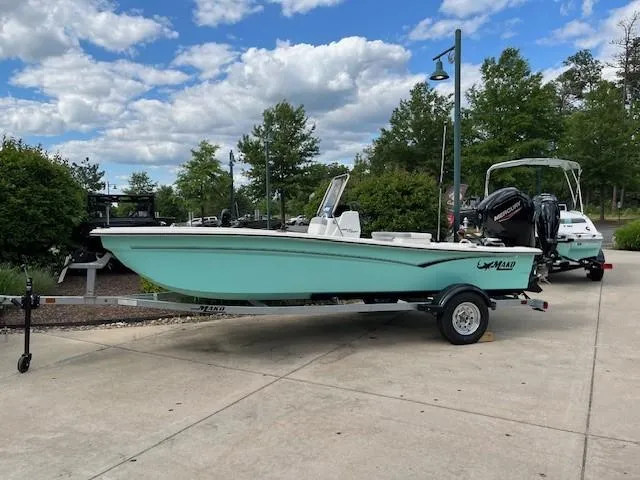 Slide: The Image of 2025 Mako Pro Skiff 17 CC boat on trailer, parked outdoors under a cloudy sky. - 43