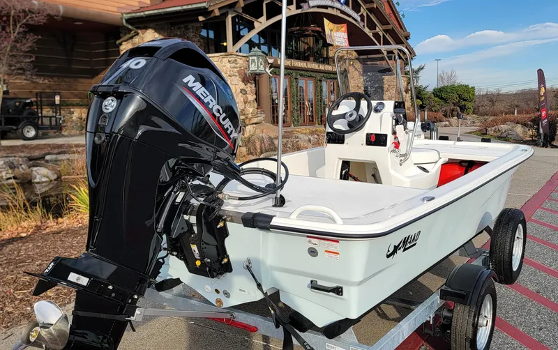 Slide: The Image of 2025 Mako Pro Skiff 13 CC boat with Mercury engine on trailer. - 2