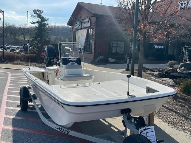 Slide: The Image of 2025 Mako Pro Skiff 17 CC boat on trailer outside a store. - 2