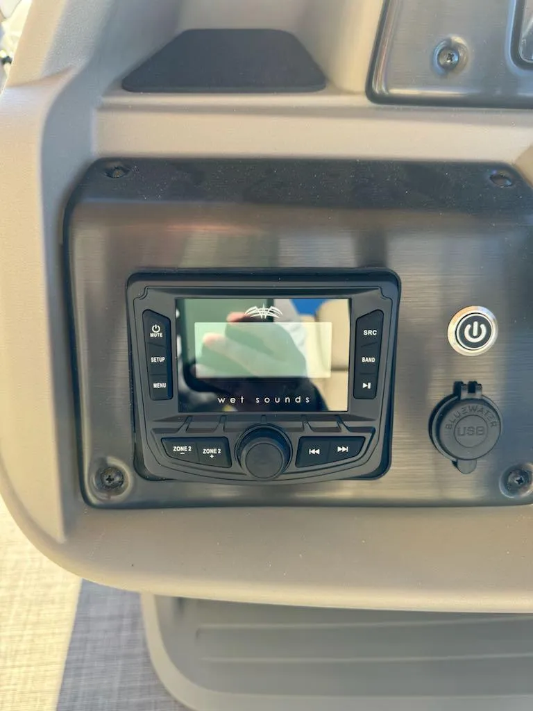 Slide: The Image of 2025 Sun Tracker SportFish 20 DLX boat dashboard with audio controls. - 13
