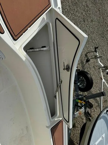 Slide: The Image of 2016 SeaVee 270Z boat storage compartment with open hatch, trailer visible. - 13