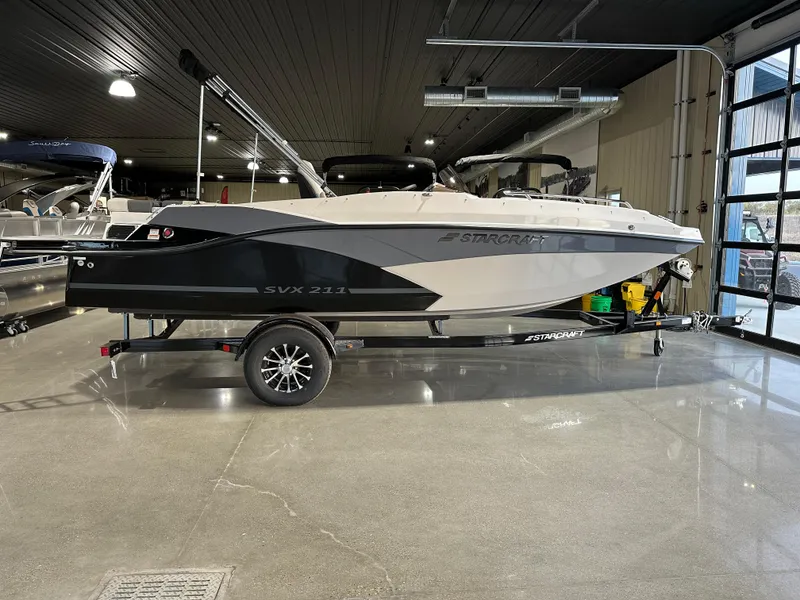 The Image of 2025 Starcraft SVX 211 IO boat on trailer in showroom. - 0