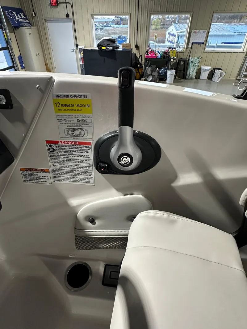 Slide: The Image of Interior view of a 2025 Starcraft SVX 211 IO boat, showcasing control lever and safety instructions. - 12